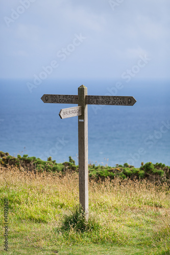 Wooden sign post for the South West Coast Path on the coast near Hope Cove, Bolberry and Cop Soar, Devon, England, UK