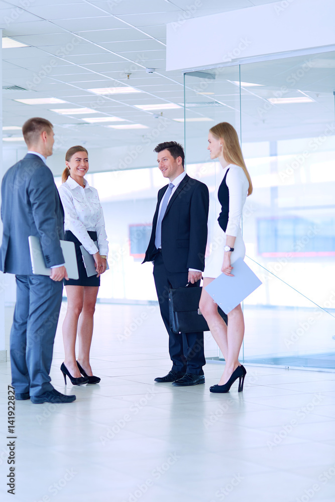 Smiling successful business team standing in office Smiling successful business team standing in office