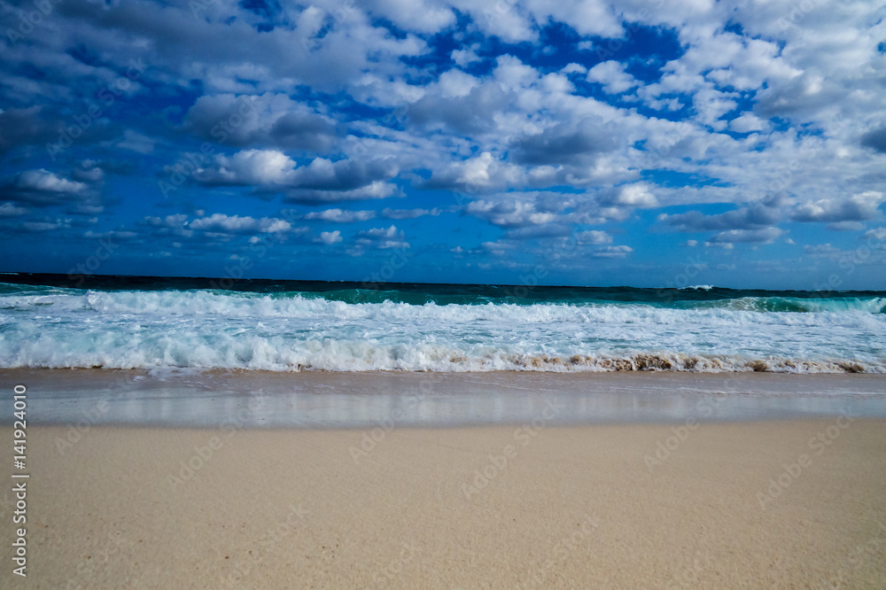 A nice tropical beach view of the ocean with clouds in the sky. New Providence, Nassau, Bahamas.