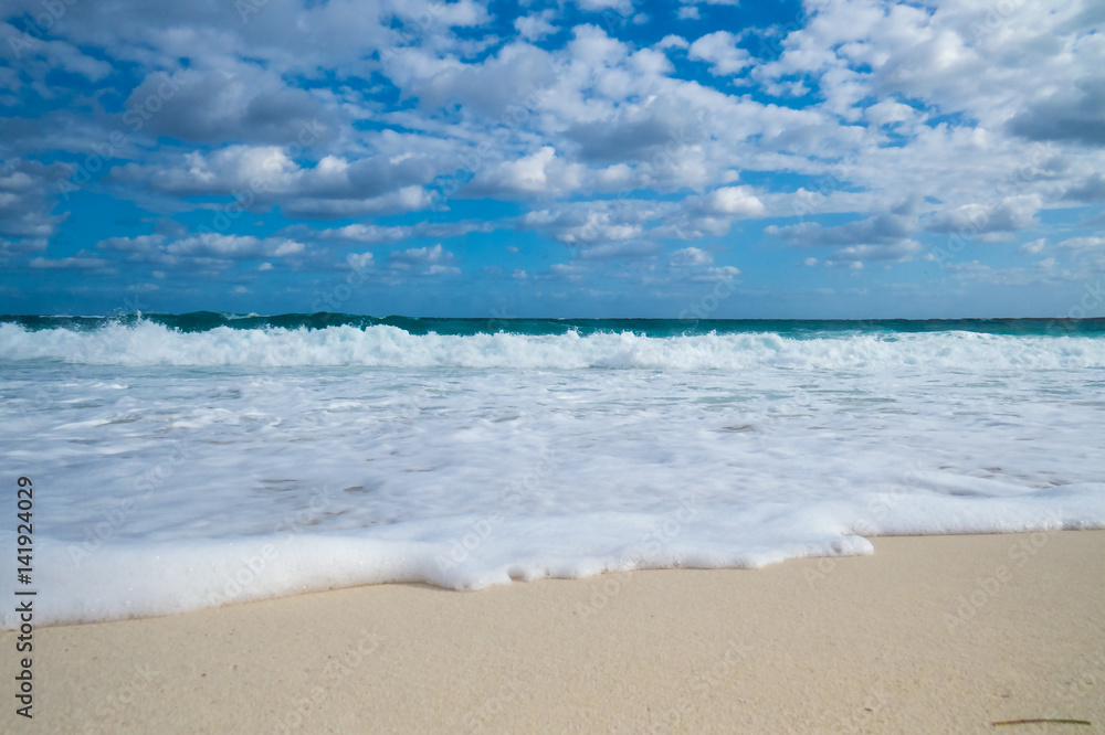 A nice tropical beach view of the ocean with clouds in the sky. New Providence, Nassau, Bahamas.