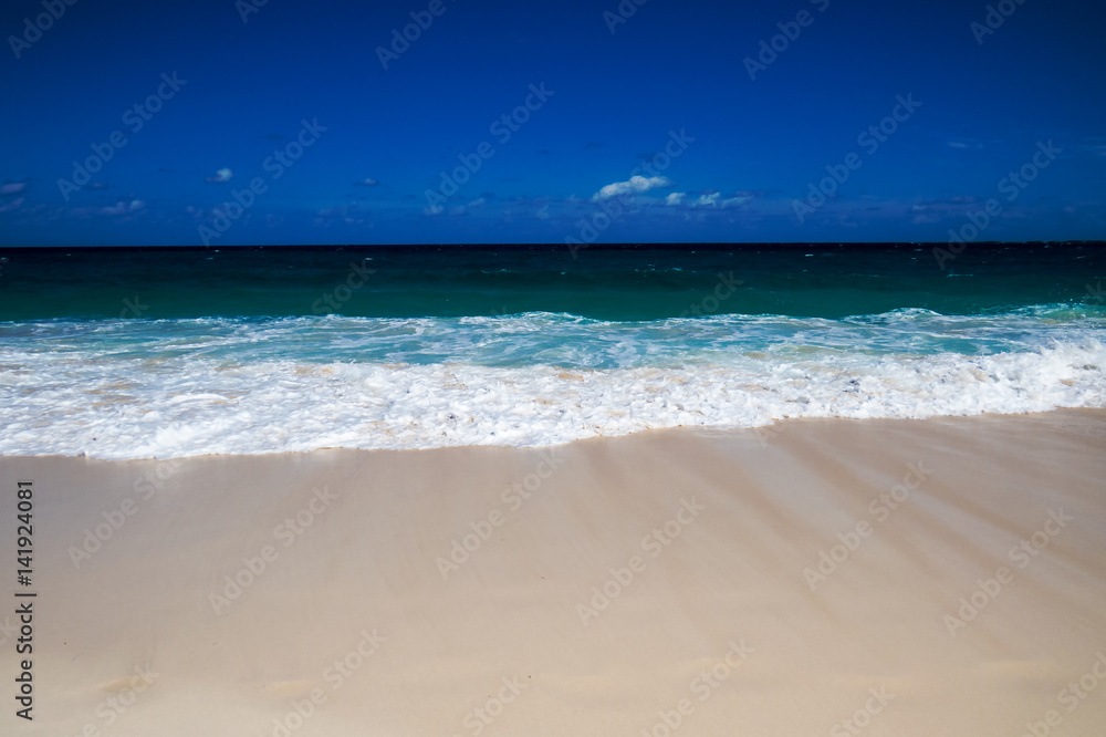 A peaceful tropical beach view of the ocean with a clean blue sky. New Providence, Nassau, Bahamas.