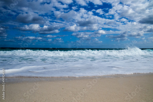 A nice tropical beach view of the ocean with clouds in the sky. New Providence, Nassau, Bahamas.