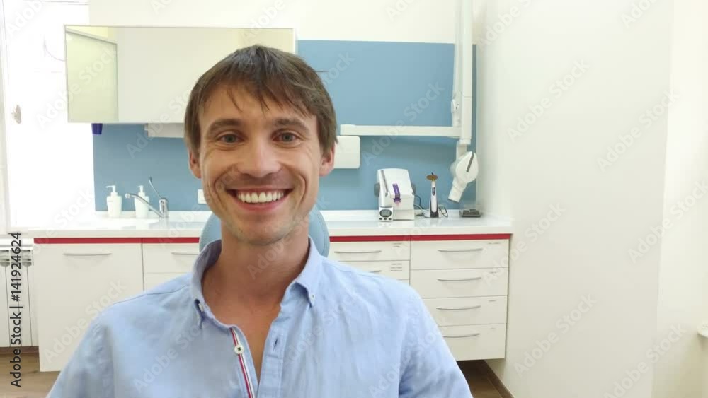 Close up of attractive smiling male patient with healthy white teeth at dentist Close up of attractive smiling male patient with healthy white teeth at dentist