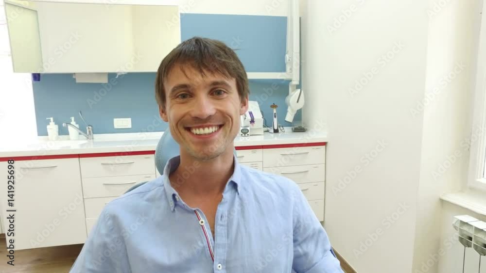Close up of attractive smiling male patient with healthy white teeth at dentist Close up of attractive smiling male patient with healthy white teeth at dentist