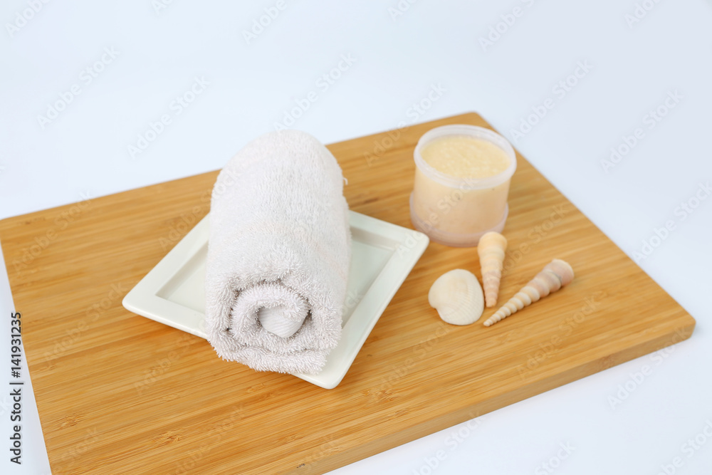Spa concept, Towels and Salt Scrub on bamboo board against white background Spa concept, Towels and Salt Scrub on bamboo board against white background
