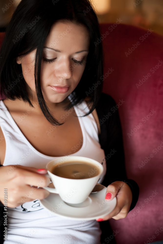 young woman sitting in a cafe drinking coffee young woman sitting in a cafe drinking coffee