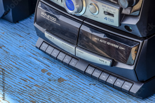 Cassette tape recorder with radio on a blue wooden table. Vintag photo