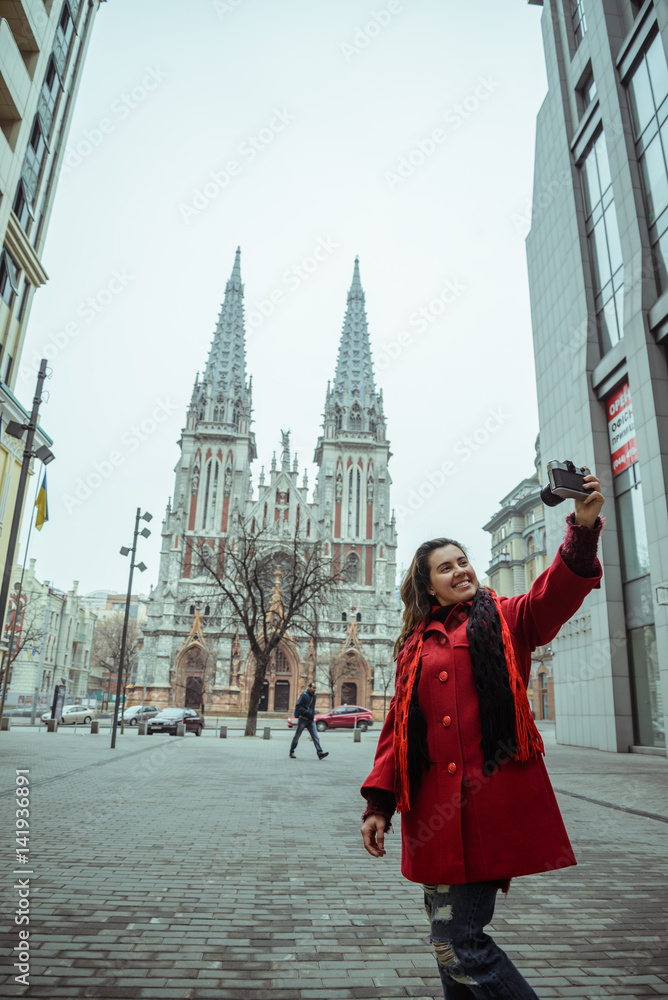 young pretty woman take selfie in front of gothic church