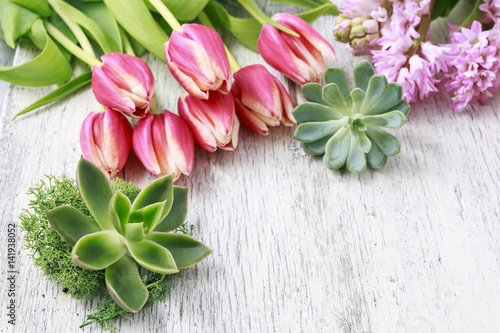 Tulips, hyacinths and succulents (echeveria) on white wood