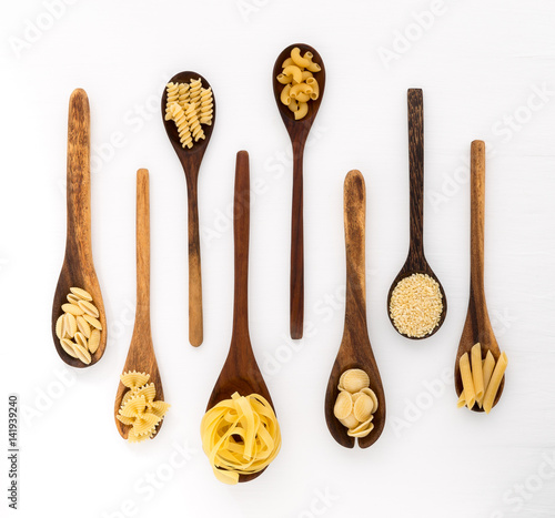 Pasta selection of penne, gnocci, rigatoni, casarecce, fiorelli, pasta Farfalle, pasta A Riso, Orecchiette Pugliesi, Gnocco Sardo and Farfalle in wooden spoons over white background