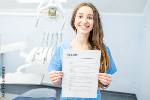 Fototapeta Naklejka Na Ścianę i Meble -  Young dentist assistant or student holding resume for a job at the dental office