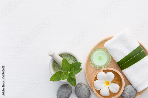 Spa concept with salt, mint, lotion, towel, candle, stone and flower on white background