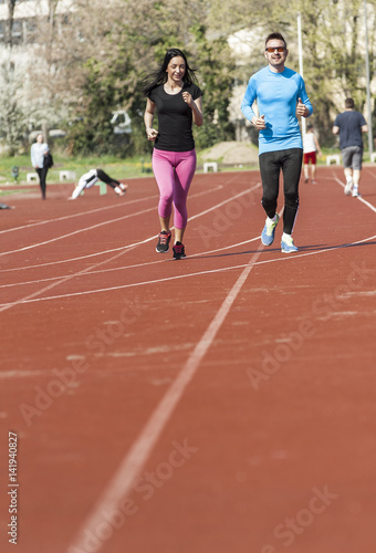 Young couple exercise running on the track