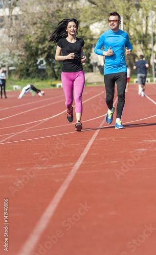 Young couple exercise running on the track