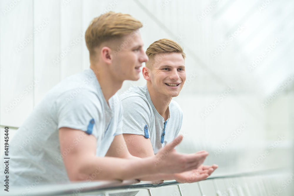 The two smile brother stand on the office balcony and gesture The two smile brother stand on the office balcony and gesture
