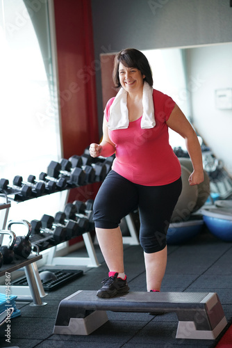 Overweight woman at the gym doing fitness exercises