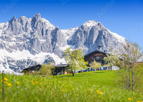 Old traditional farmhouse in front of a snowy mountain range, Kitzbuehel, Tyrol, Austria photo