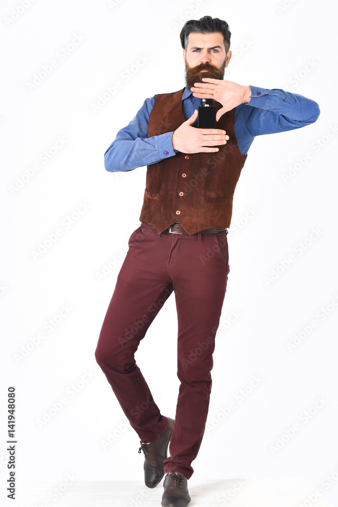 Fototapeta premium bearded man holding perfume with serious face
