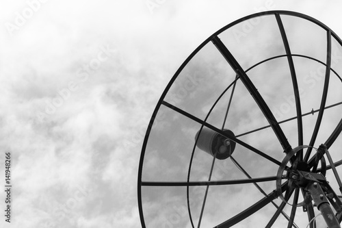 big satellite dish on blue sky background in sunny day - black and white