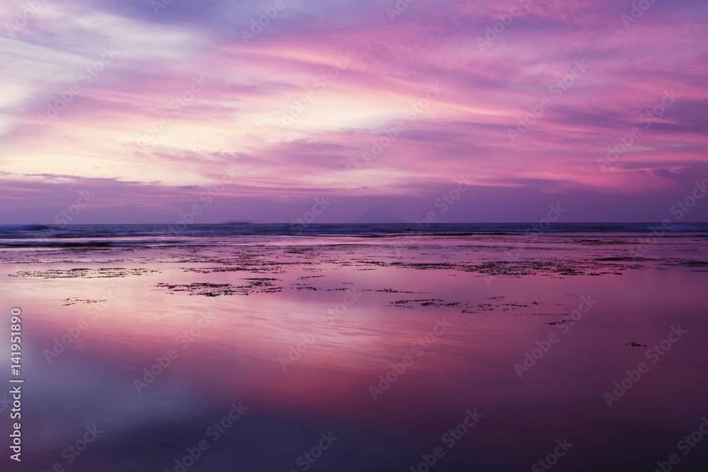 Naklejka premium Piękny zachód słońca z fioletowym niebem na plaży