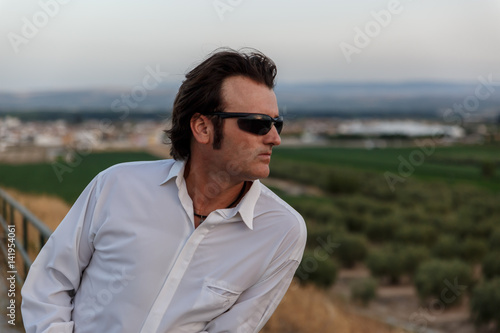 Close-up of a man leaning on a railing looking at nature