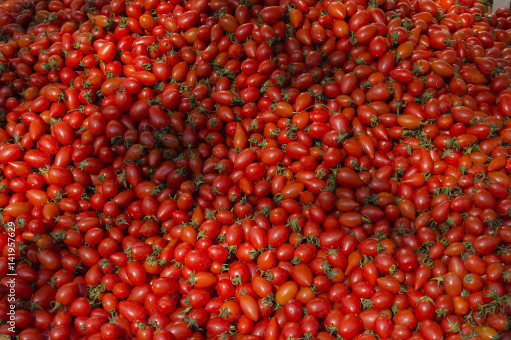 Huge pile of fresh cherry tomatoes for sale in marketplace in the sun Huge pile of fresh cherry tomatoes for sale in marketplace in the sun