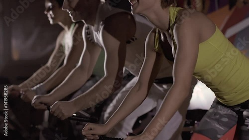 Close-up of happy sport people exercising together in the gym at night