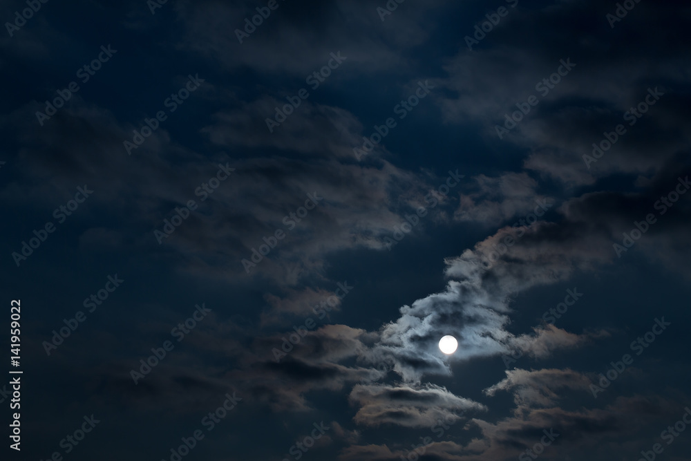 Dramatic night sky with clouds and bright full moon