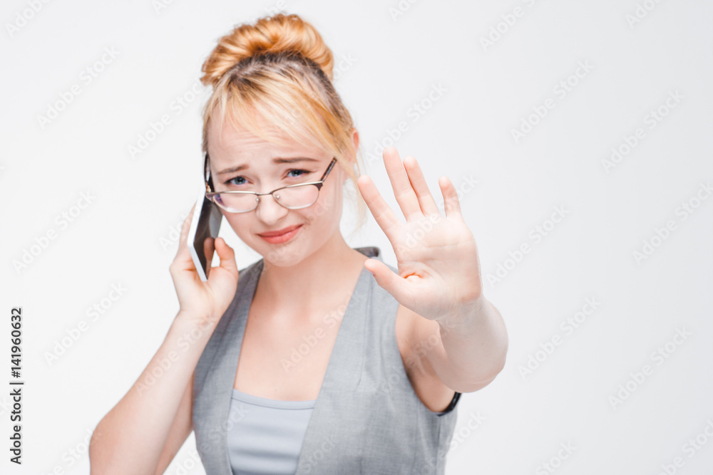 Young girl in glasses interrupted during important talking on mobile phone. Irritation, anger, annoyance of distraction. Young girl in glasses interrupted during important talking on mobile phone. Irritation, anger, annoyance of distraction.