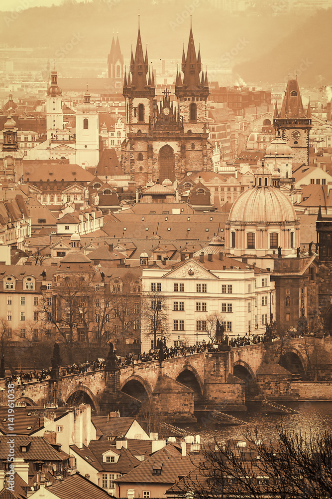 Prague historical sights, Charles bridge and old town, in misty winter day. Antique sepia retro filter.