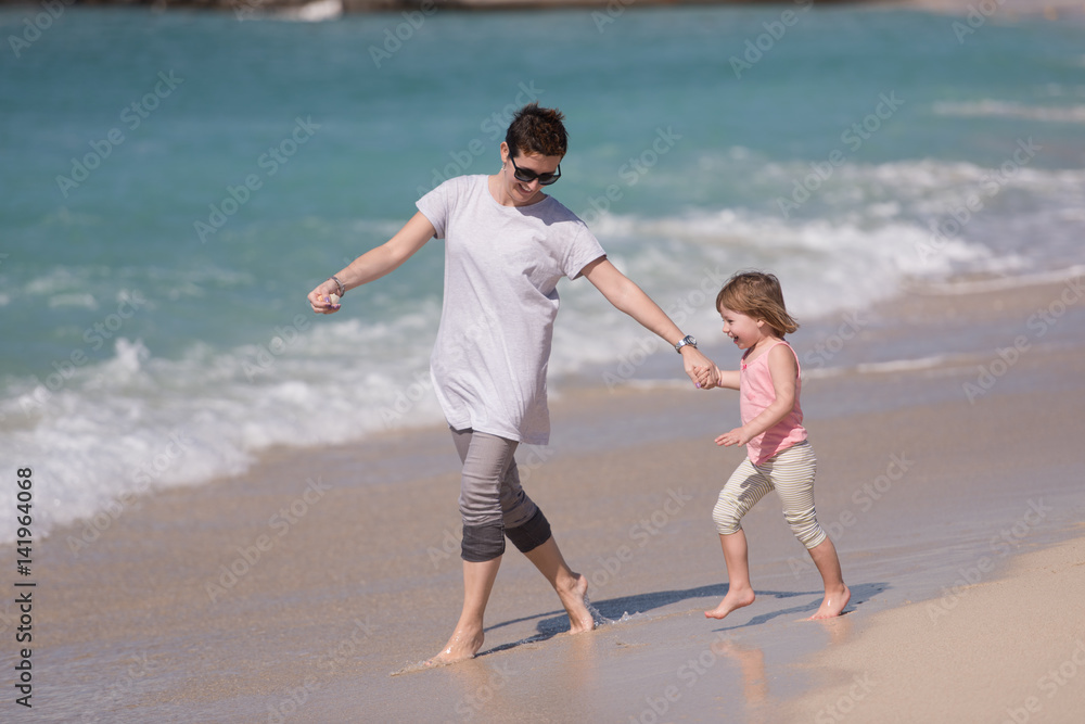 mother and daughter running on the beach mother and daughter running on the beach