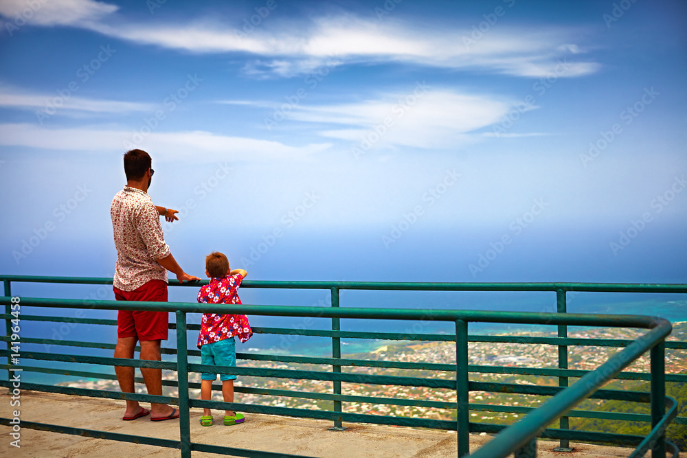 happy father and son, tourists enjoying the fascinating view on Atlantic ocean coastline from observation deck of Pico Isabel de Torres