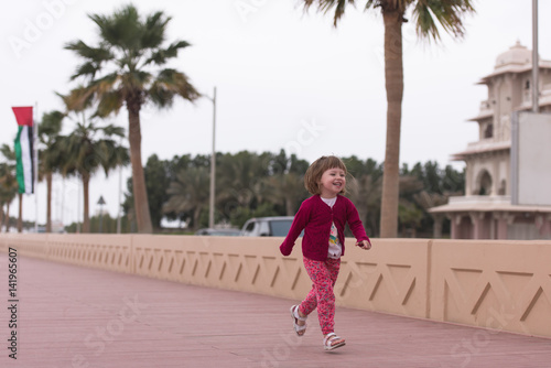 cute little girl on the promenade by the sea