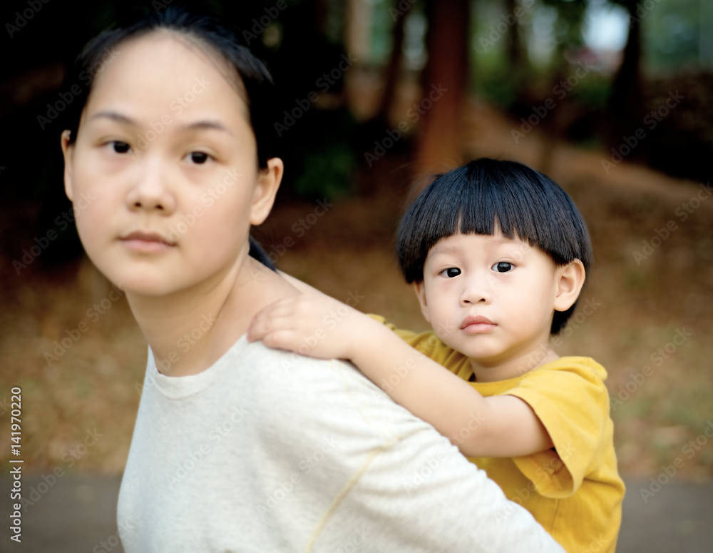 Closeup young boy on back of his mother Closeup young boy on back of his mother