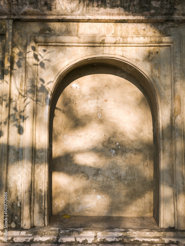 Bild auf Leinwand Old wall with stone alcove and recess with sunlight in buddhist temple, wall bac