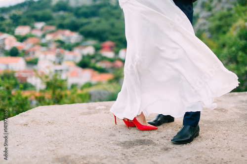 Legs is newlywed on the stone floor. Wedding in Montenegro.