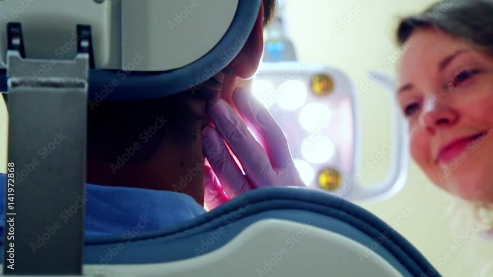 Low Angle Close Up Of Beautiful Female Dentist Turning On Lamp And Low Angle Close Up Of Beautiful Female Dentist Turning On Lamp And