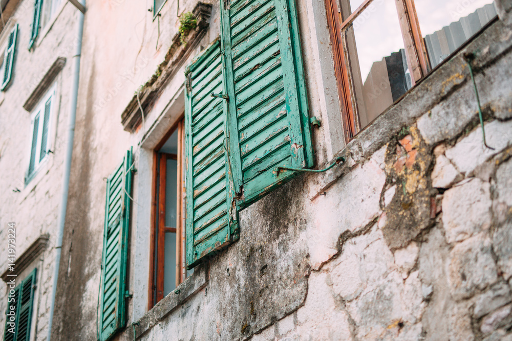 Green window shutters. The facade of houses in Montenegro.