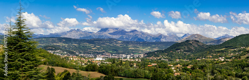 The city of Gap in the Hautes Alpes with surrounding mountains and peaks in Summer. Panoramic. Southern French Alps, France