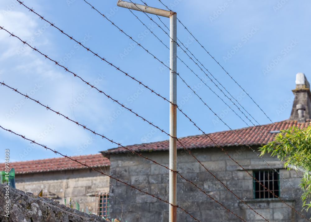 barbed wire in front of the prison building barbed wire in front of the prison building