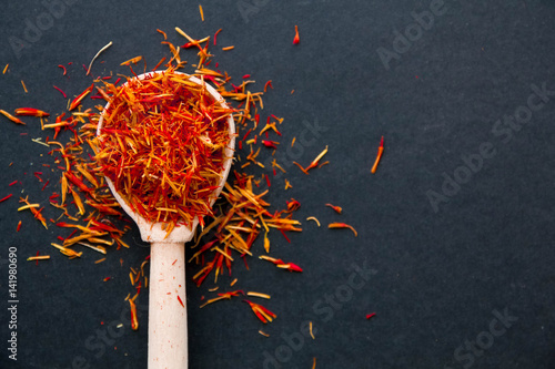 Saffron in a spoon on a dark background, selective focus, macro shot, shallow depth of field  photo