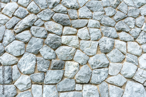 Background wall made of stones held together with cement. Wall made of stones close-up