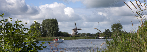 Dutch landscape. River Linde at Wolvega. Windmill and boats on canal. Panorama. Friesland. photo