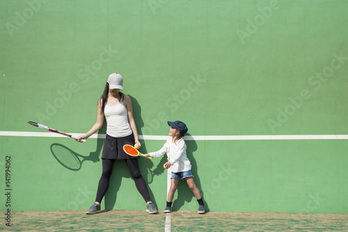 テニスをする母と娘