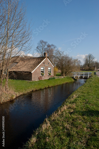 Little house and wooden bridge in National Park Weerribben de wieden Netherlands. Tiny house. Kalenberg Overijssel. photo