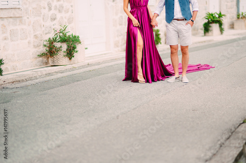 Couple holding hands in the old city. A newly married couple in a field with an old city holding hands. Wedding in Montenegro.