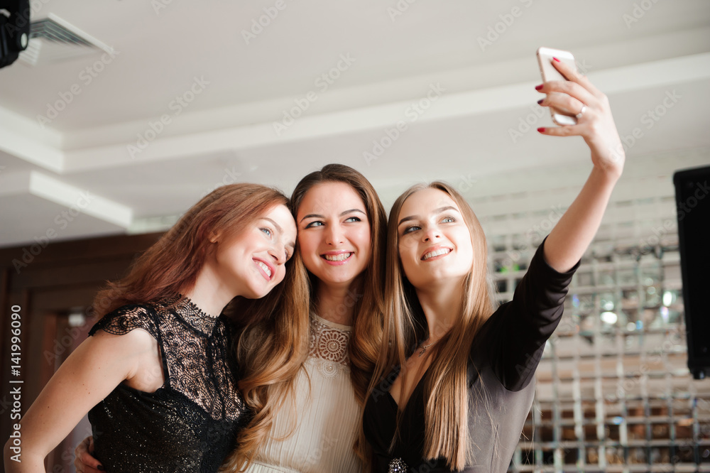 Three young girls are doing selfie photo in a restaurant Three young girls are doing selfie photo in a restaurant