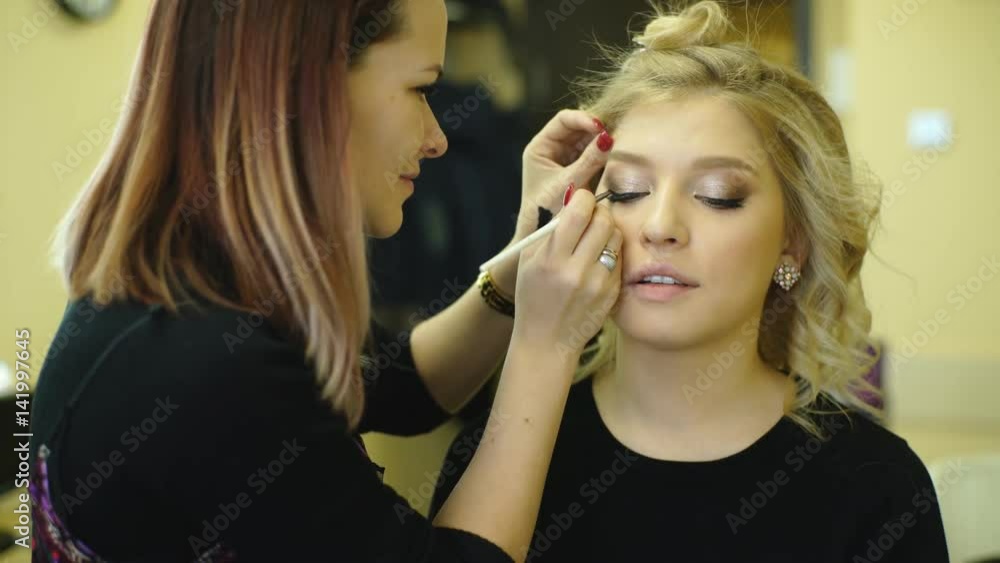 Young beautiful woman applying make-up by make-up artist Young beautiful woman applying make-up by make-up artist
