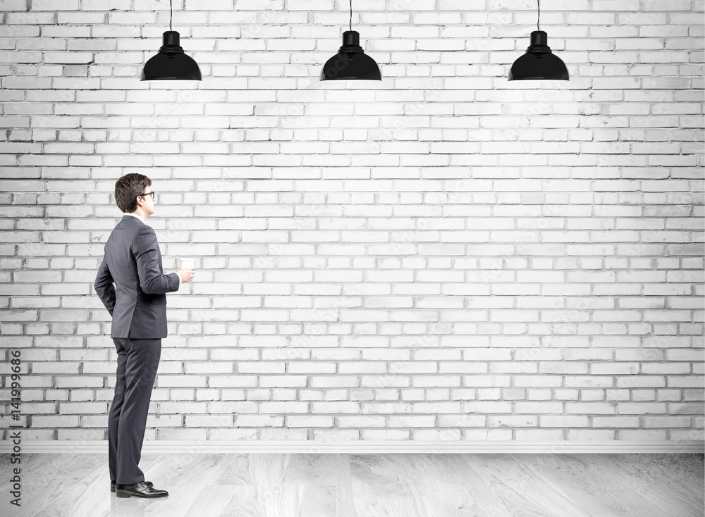 Businessman with coffee and a brick wall Businessman with coffee and a brick wall