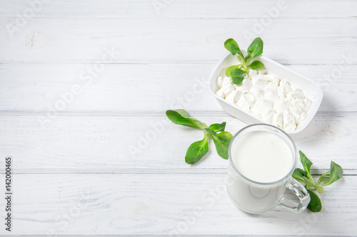 Cup of yogurt and cheese on wooden background. Top view.